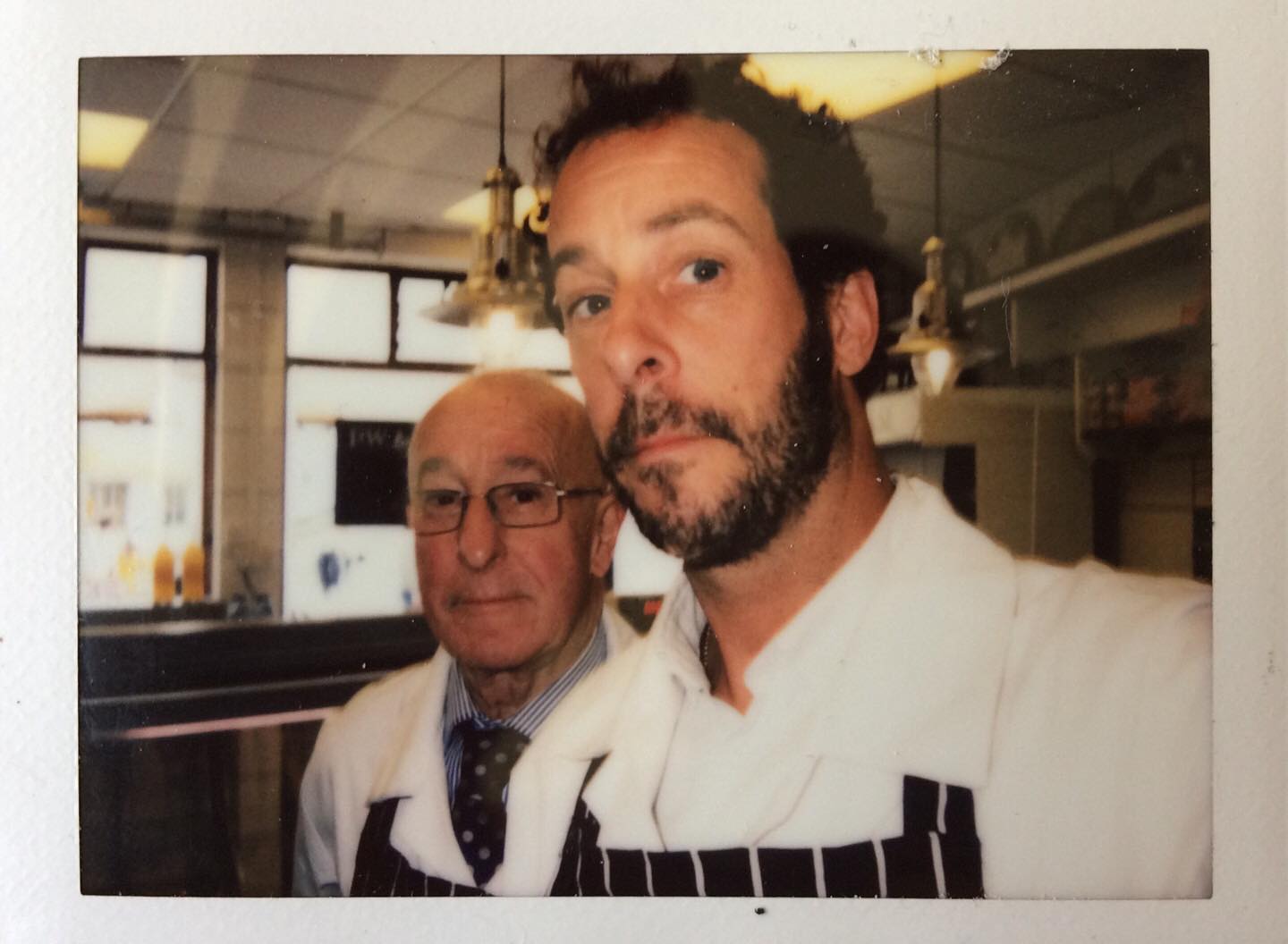 Paul and Matthew Coleman in butchers whites inside the shop